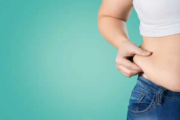 Image of woman pinching her love handles to show weight gain Market Drayton